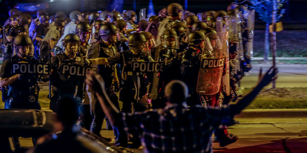 Police move in on a group of protesters throwing rocks at them in Milwaukee. Photo / AP