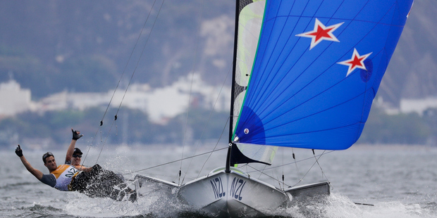 New Zealand's Blair Tuke, left, and Peter Burling celebrate after crossing the finish line. Photo / AP