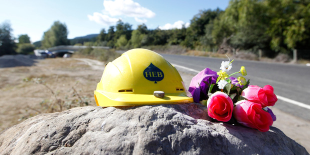 A construction hat and flowers are left by the side of the road in memory of George Taiaroa when he was shot dead in March 2013. Photo / File