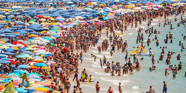 It's not always easy finding a patch of sand on Spain's popular beaches but authorities are getting wise to tourists' tricks. Photo / Getty Images
