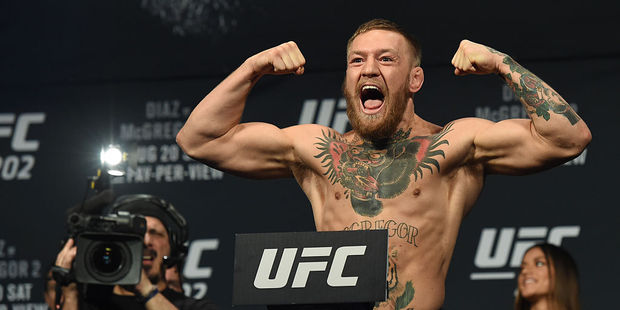 UFC featherweight champion Conor McGregor poses on the scale during his weigh-in for UFC 202. Photo / Getty Images