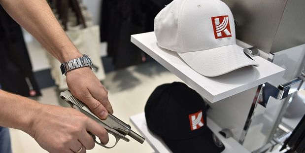A man poses with one of the model guns on sale in the Kalashnikov shop. Photo / Getty Images