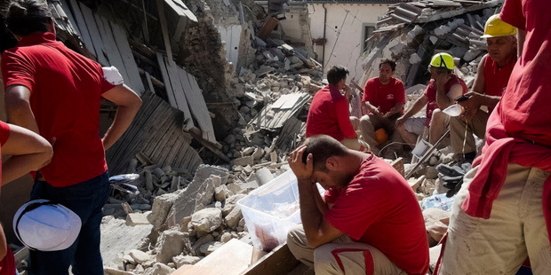 Rescuers pause in Amatrice, central Italy. Photo / AP