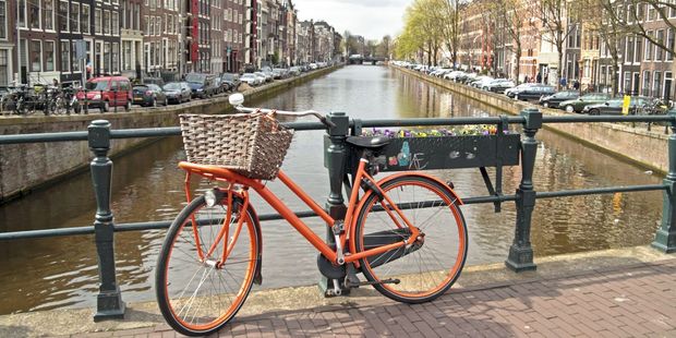 Orange bike on the bridge in Amsterdam city in the Netherlands. Photo / 123RF