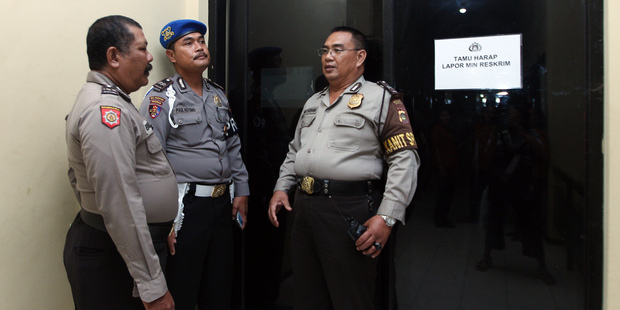 Indonesian police officers guard a door where murder suspect David Taylor is detained at police headquarters in Bali. Photo / AP