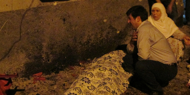 A man cries over a covered body after an explosion in Gaziantep, southeastern Turkey. Photo / AP