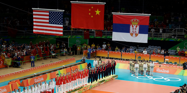 The teams of China, center, Serbia, left, and the United States watch as their flags are raised during the awards ceremony for women's volleyball at the 2016 Summer Olympics. Photo / AP