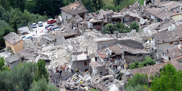 Rescuers search through debris of collapsed houses in Pescara del Tronto, Italy. Photo / AP