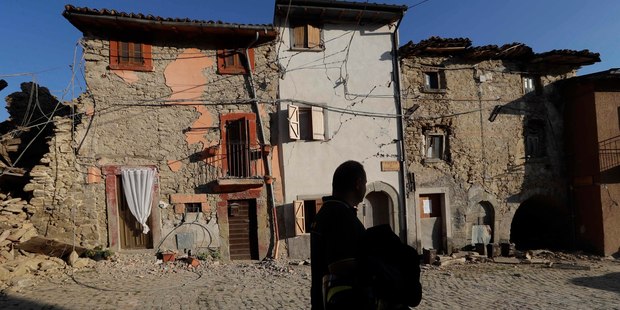 A firefighter walks past damaged houses. Photo / AP