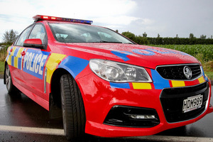 Police are hunting a man who injured a petrol station employee with a machete during an armed robbery last night.
