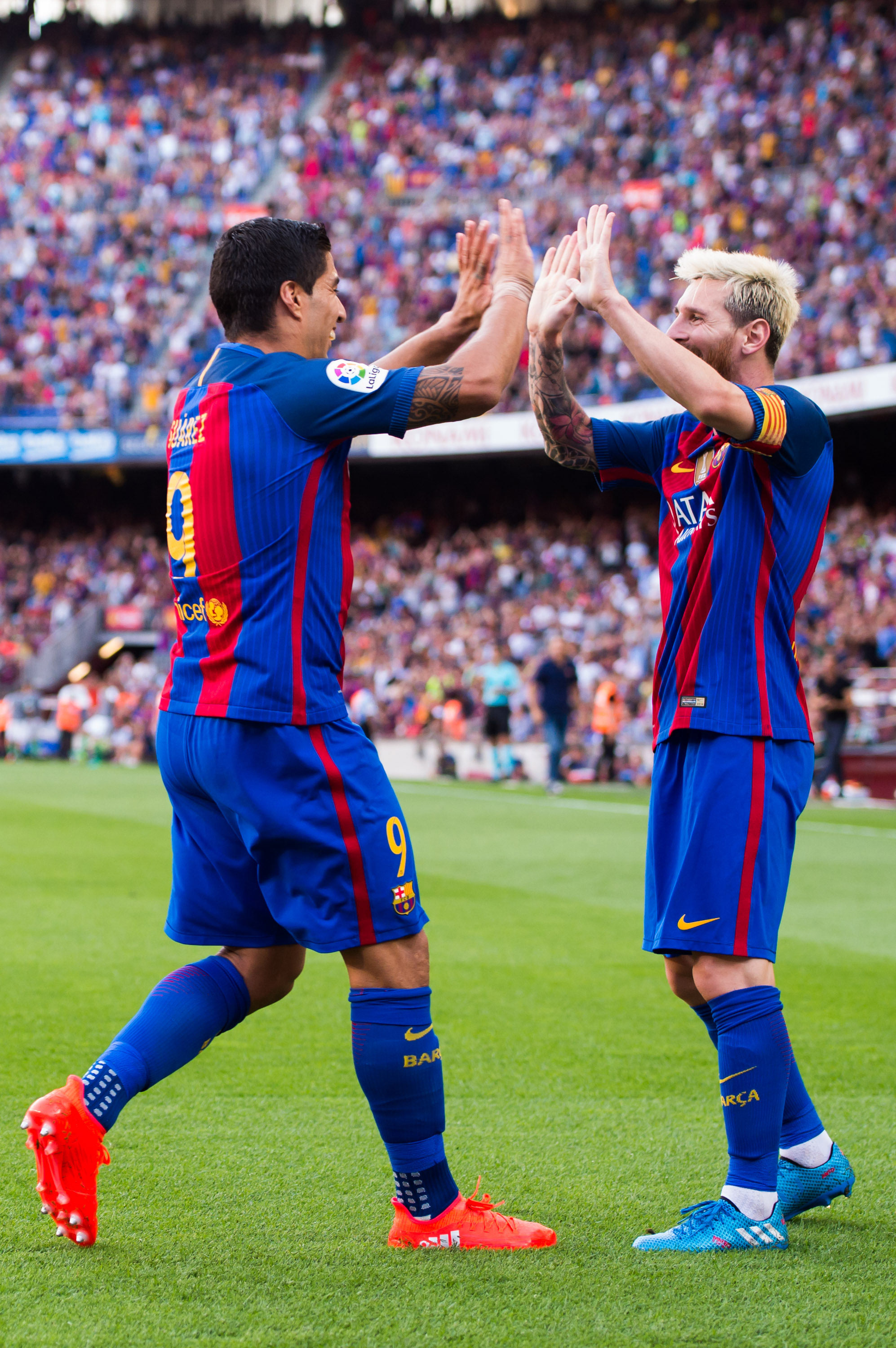 Luis Suarez (L) celebrates with Lionel Messi and their Speed of Light boots.