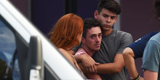 Backpackers comfort each other outside the Home Hill Backpackers after three people were stabbed. Photo / Zak Simmonds News Corp