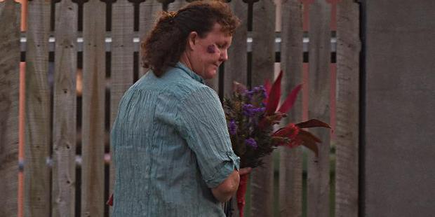 A lady arrives with flowers outside the scene where three people were stabbed. Photo / Zak Simmonds, News Corp Australia