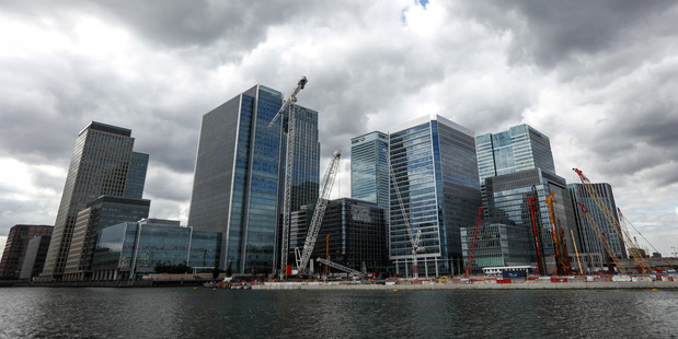 Construction cranes in front of office buildings in Canary Wharf. Photo / Simon Dawson