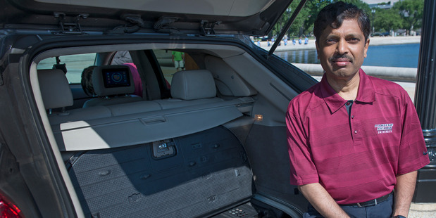 Carnegie Mellon University Professor Raj Rajkumar, shown in 2014 with the main control center of a self-driven car, said he is more convinced than ever that gradually introducing safe-driving features