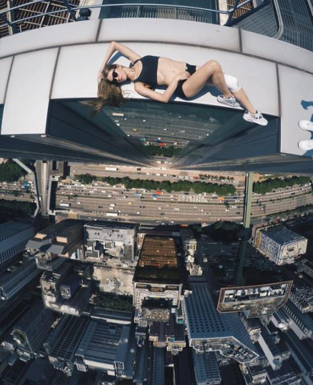 One snap of her relaxing in shorts and a top as she sunbathes just inches away from a sheer drop to the ground is captioned, "Enjoy every moment". Photo / Angela Nikolau Instagram