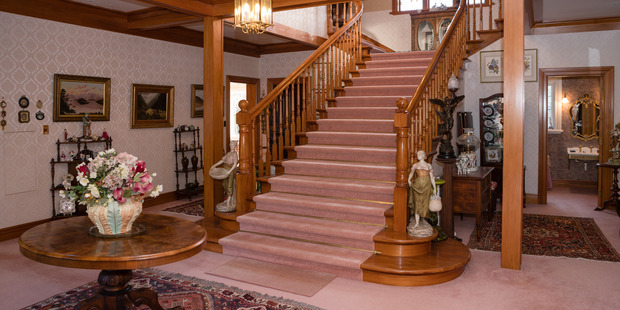 A centrepiece grand flowing double staircase rising from the generous entry of Carrington House in Carterton. Photo / Supplied