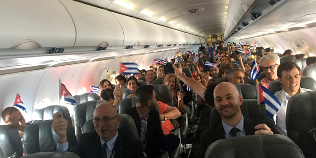 JetBlue Flight 387 passengers hold up representations of Cuba's national flag, just before touching down at the airport in Santa Clara, Cuba. Photo / AP