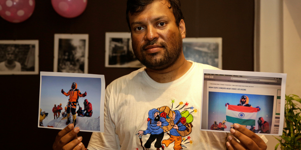 Indian climber, Satyarup Sidhantha holds on his right hand a photograph that shows him on Mount Everest, with an altered version of the same photo. Photo / AP