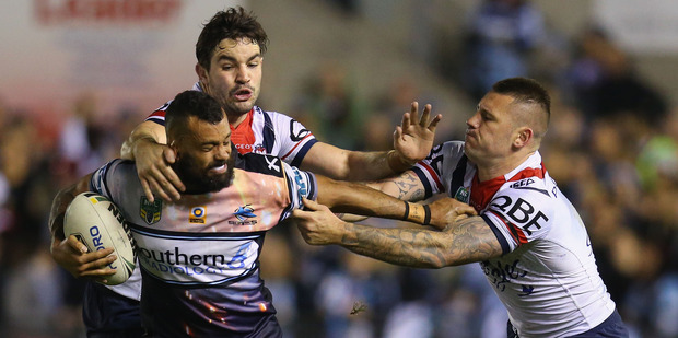 Jayson Bukuya of the Sharks is tackled by Roosters players at Shark Park in Sydney last night. Photo / Getty Images