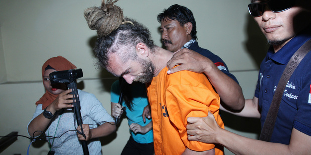 Indonesian police officers escort murder suspect David Taylor to an investigator's room at a local police station in Bali. Photo / AP