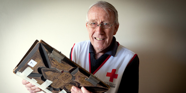 Red Cross volunteer David Garland with a bible from the 1800's at the Red Cross Book Fair. Photo/Andrew Warner