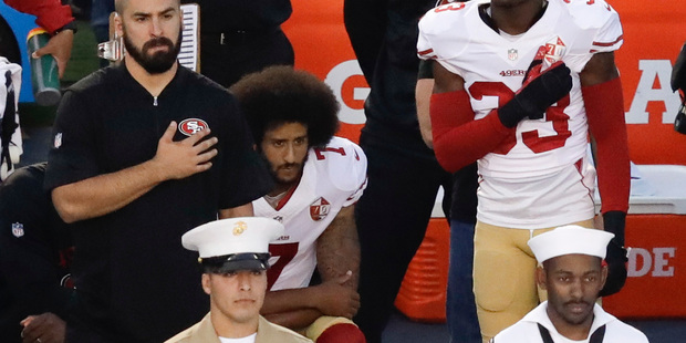 San Francisco 49ers quarterback Colin Kaepernick kneels during the national anthem. Photo / AP