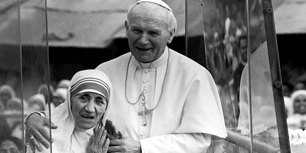 Pope John Paul II, right, holds his arm around Mother Teresa as they ride in the Popemobile outside the Home of the Dying in Calcutta, India, in 1986 photo. Photo / AP