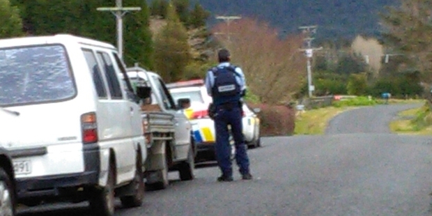 A policeman looks down the road in rural Katikati, where an armed cordon has been set up by police this afternoon. Photo/Andrew Warner