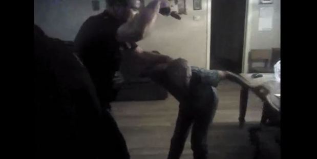 The footage shows police kicking open Geneva Smith's front door in pursuit of her 56-year-old son. Photo / AP