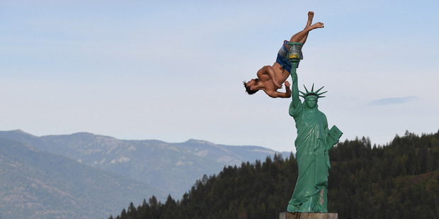 Jacob Clad, 22, performs a flip into Lake Pend Oreille near a replica of the Statue of Liberty in Sandpoint, Idaho. Photo / The Washington Post