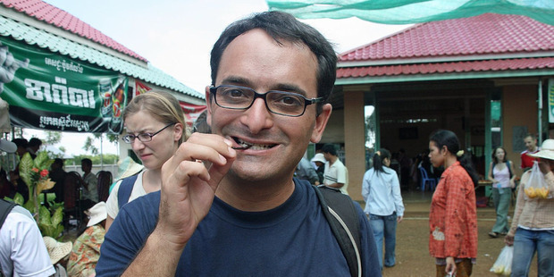A tourist samples a tarantula leg - the only part worth eating. Photo / Flickr, Michael Klein