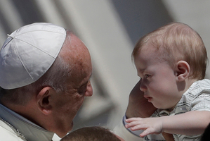 Pope Francis with a baby in St Peter's Square at the Vatican. Italy is facing a dramatic demographic change, with increasingly fewer children being born. Photo / AP