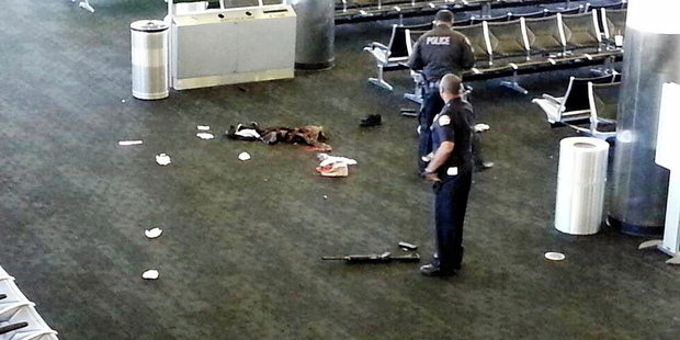 Police officers stand near a weapon inside Terminal 2 at Los Angeles International Airport after a shooting incident in 2013. Photo / AP