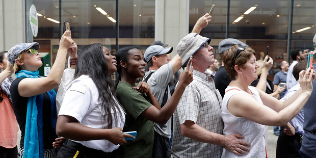 People photograph Republican presidential candidate Donald Trump's motorcade as it drives in Philadelphia. Photo / AP