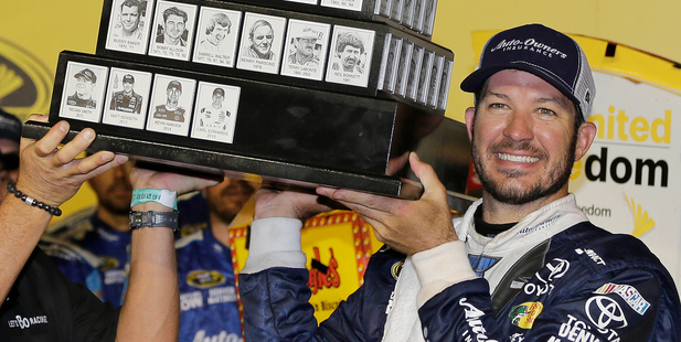 Martin Truex Jr. holds his trophy in Victory Lane after winning the NASCAR Sprint Cup Southern 500. Photo / AP