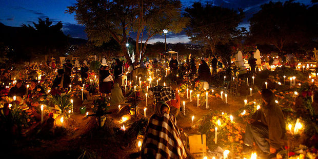 Villagers visit the graves of relatives during the Day of the Dead celebrations in Oaxaca. Photo / Getty Images