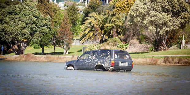 Car in the estuary off Maxwell Road, near Otumoetai. It's a race against the incoming tide to get the car out. Photo/Andrew Warner.