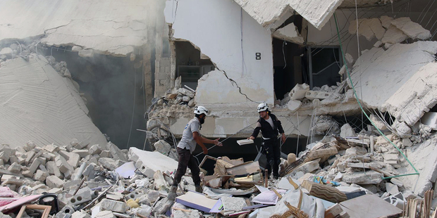 Syrian civil defense workers inspect damaged buildings, after barrel bombs were dropped on Aleppo, Syria at the end of August. Photo / Aleppo Media Center