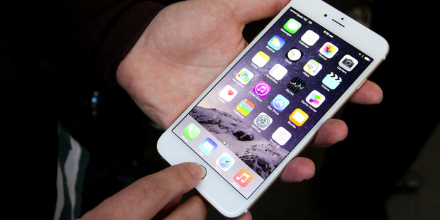 A Spark representative displaying the iPhone 6 and 6+ at the Spark store on Queen Street. Photo / Jason Oxenham
