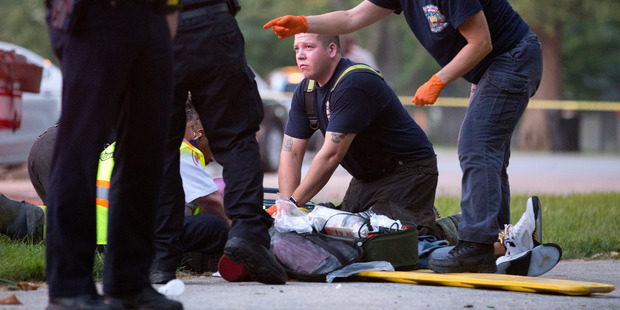 The Chicago Fire Department work on a gunshot victim at the scene of a double shooting in Ogden Park, in the Englewood neighbourhood of Chicago on Monday. Photo / AP
