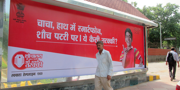 A campaign across India shows children making fun of people who buy smartphones, flat-screen TVs and motorcycles but continue to defecate in the open. Photo / Rama Lakshm, Washington Post