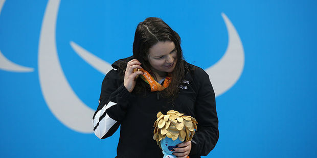 Gold medalist Mary Fisher of New Zealand listens to the sound of the medal on the podium. Photo / Getty Images