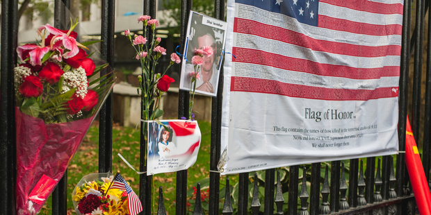 Flowers and a US flag of honour with the names of all those people who perished in the terrorist attacks of 9.11., New York City. Photo / Getty Images