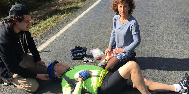 A cyclist lies in Woodcocks Rd, Warkworth, on Saturday after being found unconcious in the road. On the right is Sue O'Callaghan. Photo / Supplied