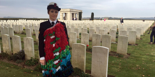 Able musician Rebecca Nelson, who wore a cloak of New Zealand bird feathers, stands at the Caterpillar Cemetery in Langueval, France, after performing at the dawn service. Photo / Kieran Campbell