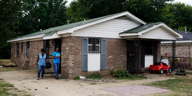 Pastor Mary Moore, left, and Janie Hendrix view the home where fire killed nine people. Photo / AP