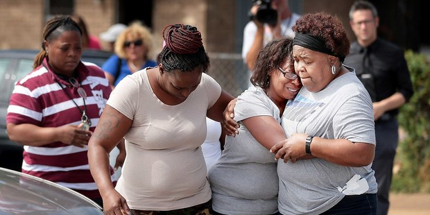 Veronica Trammell, centre, is comforted as family members gather outside the scene of a fatal fire. Photo / AP