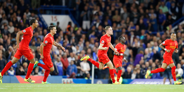 Liverpool's Jordan Henderson, center, celebrates after scoring his side's second goal during the English Premier League soccer match between Chelsea and Liverpool. Photo / AP.
