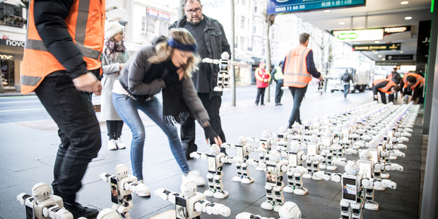 Robots queue for the iPhone 7 for those too busy to queue themselves, at the Spark store on Queen St, Auckland. Photo / Michael Craig